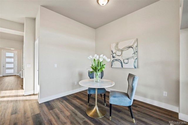 dining space featuring baseboards and wood finished floors