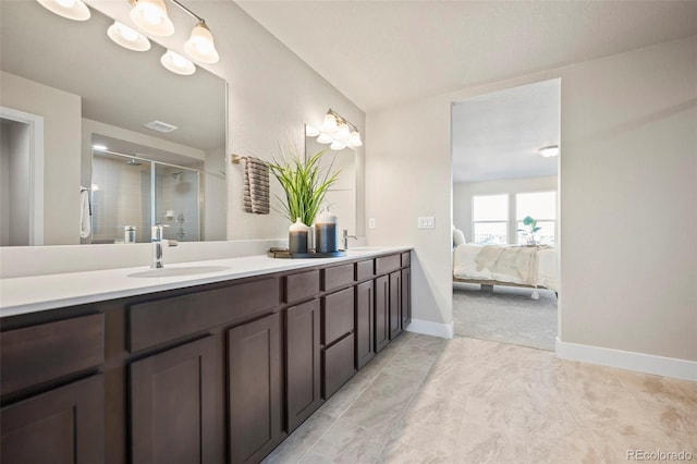 full bath with ensuite bathroom, double vanity, a sink, and a shower stall