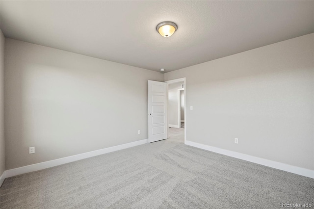 empty room featuring carpet floors and baseboards