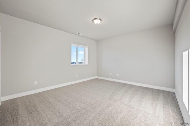 carpeted empty room with baseboards