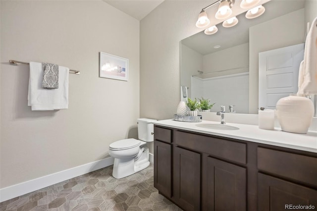 full bathroom with baseboards, vanity, toilet, and walk in shower