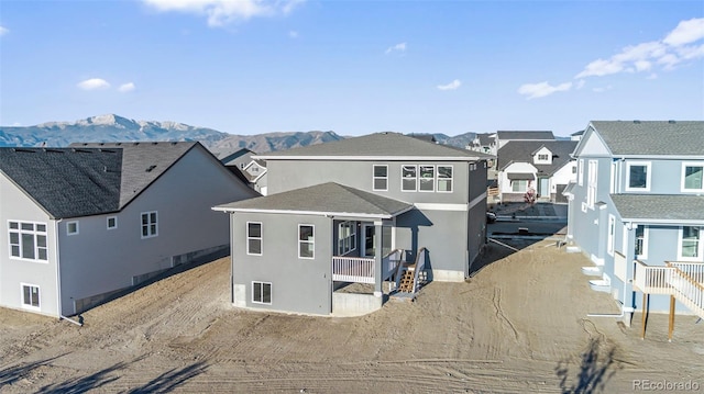 rear view of house featuring a residential view, a mountain view, and stucco siding