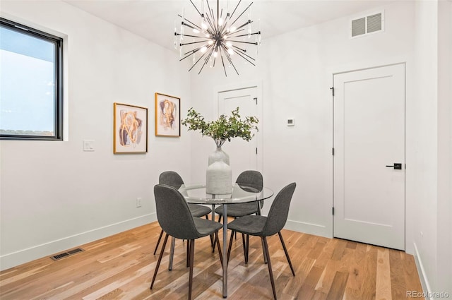 1715 Grove St, Denver, CO 80204 - dining space featuring a chandelier, light wood-style flooring, and baseboards