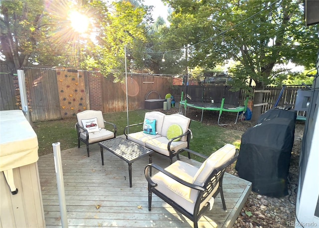 wooden terrace with an outdoor hangout area and a trampoline