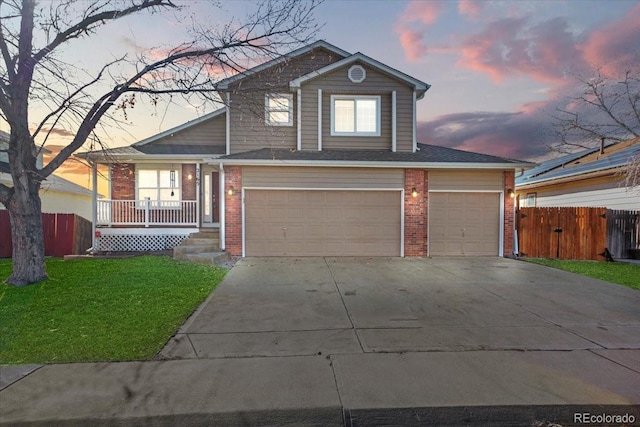 front facade with a garage, a lawn, and a porch