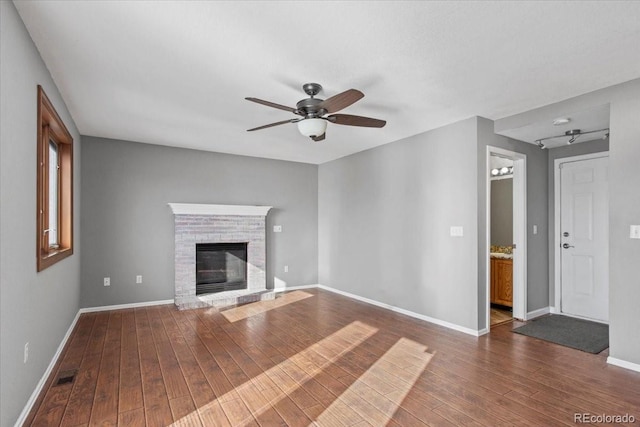 unfurnished living room featuring dark wood-type flooring and ceiling fan