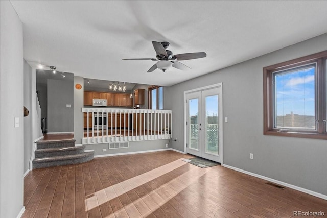 unfurnished living room featuring wood-type flooring, ceiling fan, and french doors