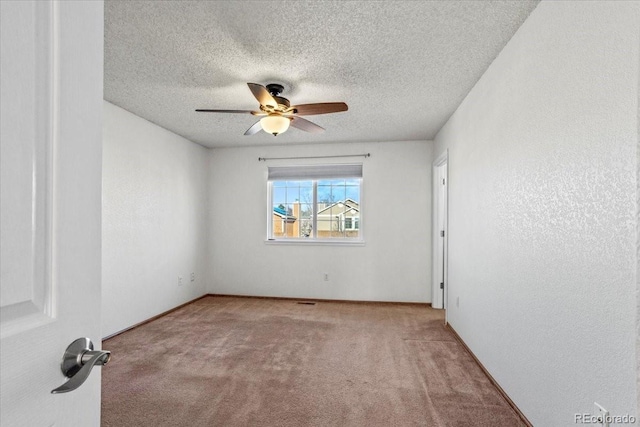 carpeted empty room featuring a textured ceiling and ceiling fan