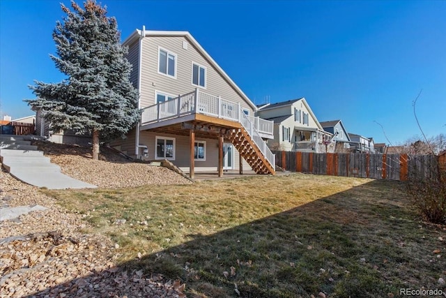 rear view of property featuring a deck and a lawn