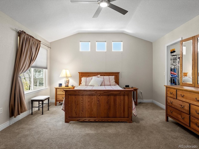 bedroom with light colored carpet, multiple windows, vaulted ceiling, and a ceiling fan