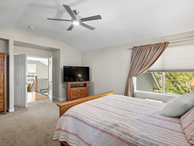 carpeted bedroom featuring vaulted ceiling, multiple windows, baseboards, and a ceiling fan