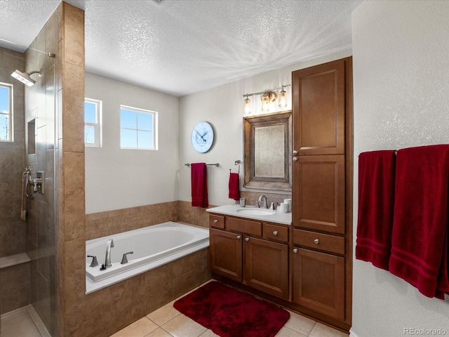 bathroom featuring a stall shower, a garden tub, a textured ceiling, vanity, and tile patterned floors