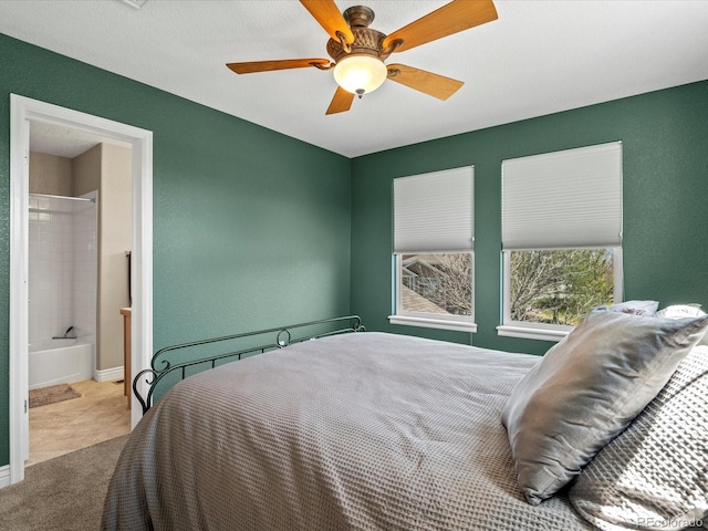 carpeted bedroom featuring ceiling fan, connected bathroom, and baseboards