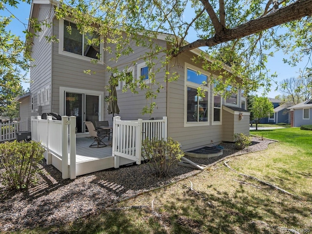 back of property featuring a deck and a yard