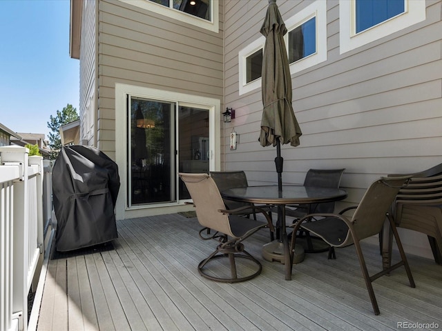 deck with outdoor dining space and a grill