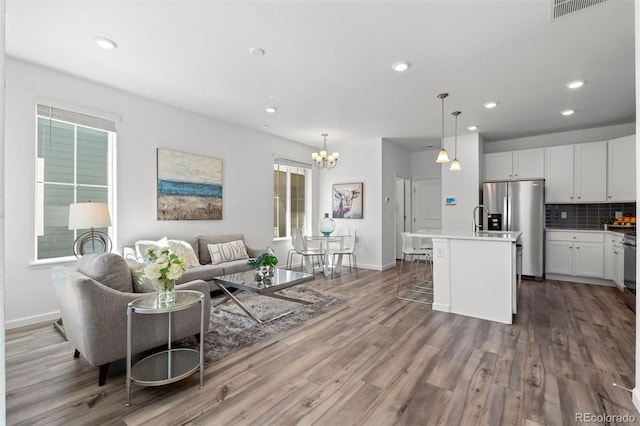 living room featuring a notable chandelier, light hardwood / wood-style flooring, and a wealth of natural light