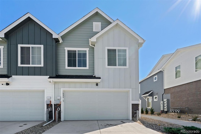 view of front facade with board and batten siding, driveway, and a garage