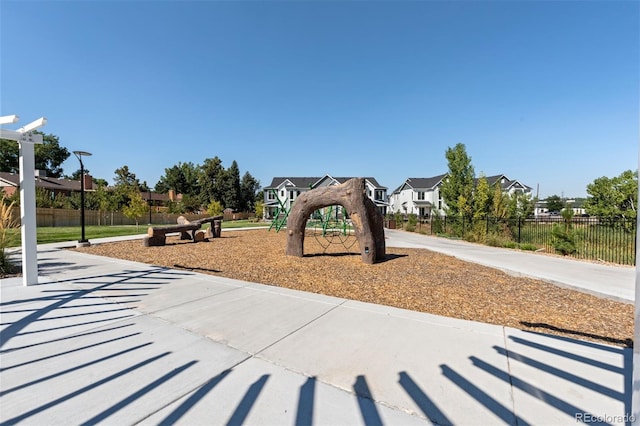 community jungle gym featuring a residential view and fence