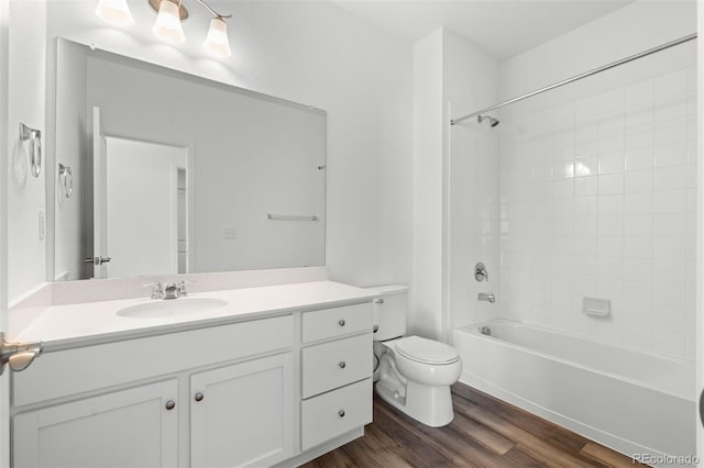 bathroom featuring toilet, bathtub / shower combination, wood finished floors, and vanity