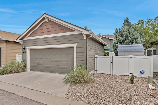 4578 Quandary Peak St, Brighton, CO 80601 - view of side of property with a gate, an attached garage, driveway, and an outdoor structure
