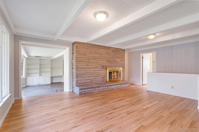 8813 Baseline Rd, Lafayette, CO 80026 - unfurnished living room featuring beam ceiling, a fireplace, plenty of natural light, and light wood finished floors