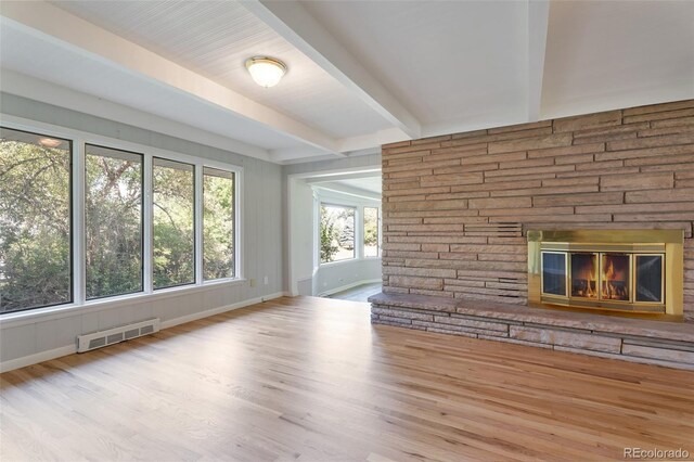 8813 Baseline Rd, Lafayette, CO 80026 - unfurnished living room featuring a fireplace, beamed ceiling, wood finished floors, and baseboards