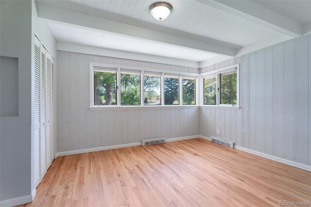 8813 Baseline Rd, Lafayette, CO 80026 - unfurnished bedroom with baseboards, wood finished floors, a closet, beamed ceiling, and wood walls