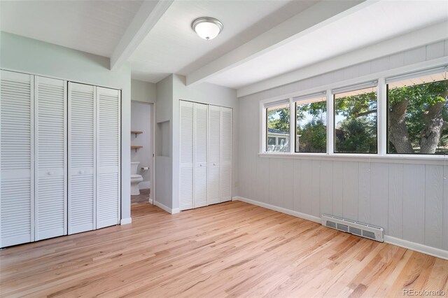 8813 Baseline Rd, Lafayette, CO 80026 - unfurnished bedroom featuring two closets, beam ceiling, wood finished floors, and baseboards