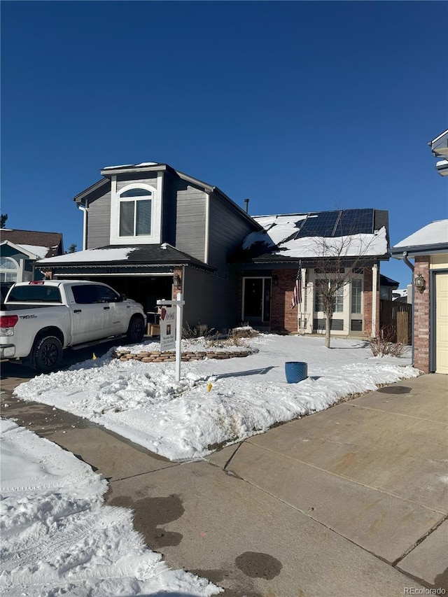 view of front of property with solar panels and a garage