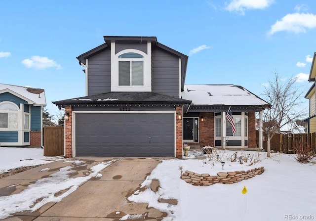 traditional-style house with a garage, fence, and brick siding