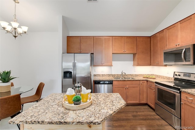 804 Summer Hawk Dr Unit 7301, Longmont, CO 80504 - kitchen with stainless steel appliances, dark wood-style floors, a sink, an inviting chandelier, and light stone counters
