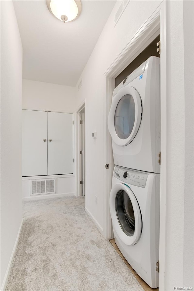 804 Summer Hawk Dr Unit 7301, Longmont, CO 80504 - laundry room with visible vents, carpet, baseboards, stacked washer and dryer, and laundry area