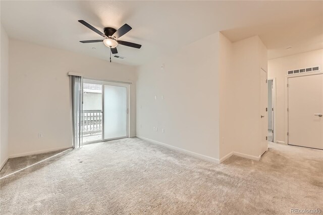 spare room with light colored carpet, visible vents, and baseboards