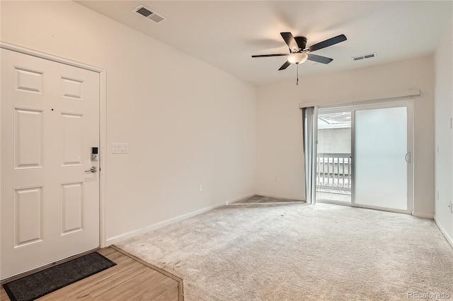 entryway with carpet, baseboards, visible vents, and ceiling fan