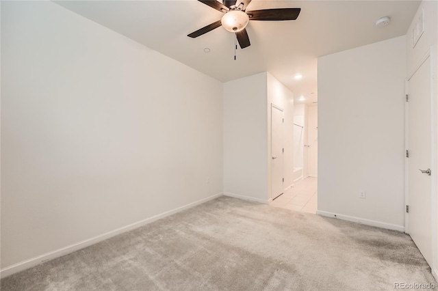 unfurnished room featuring light carpet, ceiling fan, and baseboards