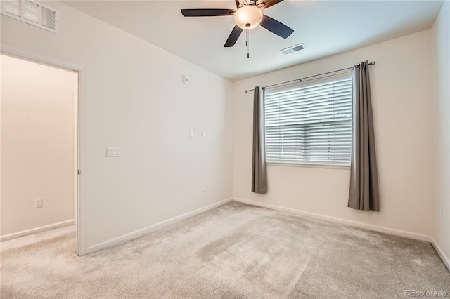 empty room featuring ceiling fan, baseboards, visible vents, and light colored carpet