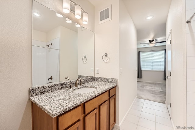 full bath featuring a ceiling fan, vanity, visible vents, tiled shower, and tile patterned floors