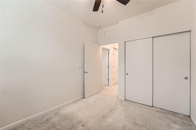 unfurnished bedroom featuring light colored carpet, a ceiling fan, baseboards, visible vents, and a closet