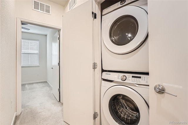 washroom with light carpet, stacked washing maching and dryer, laundry area, and visible vents