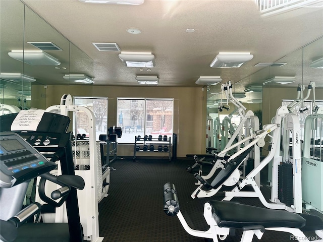 exercise room featuring visible vents and a textured ceiling