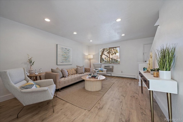 living room with a wall mounted AC, light hardwood / wood-style flooring, and a baseboard radiator