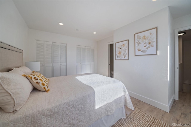 bedroom featuring two closets and light hardwood / wood-style flooring