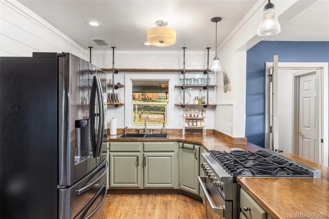 377 Homestead Rd, Bailey, CO 80421 - kitchen with fridge with ice dispenser, stainless steel range with gas stovetop, green cabinetry, light wood finished floors, and decorative backsplash
