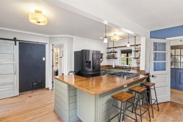 377 Homestead Rd, Bailey, CO 80421 - kitchen with fridge with ice dispenser, stainless steel gas cooktop, light wood-style flooring, a peninsula, and a breakfast bar area