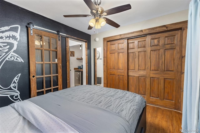 377 Homestead Rd, Bailey, CO 80421 - bedroom with a barn door, wood finished floors, and ceiling fan