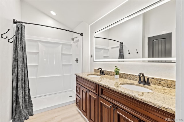 377 Homestead Rd, Bailey, CO 80421 - bathroom with a shower with shower curtain, double vanity, wood finished floors, and lofted ceiling