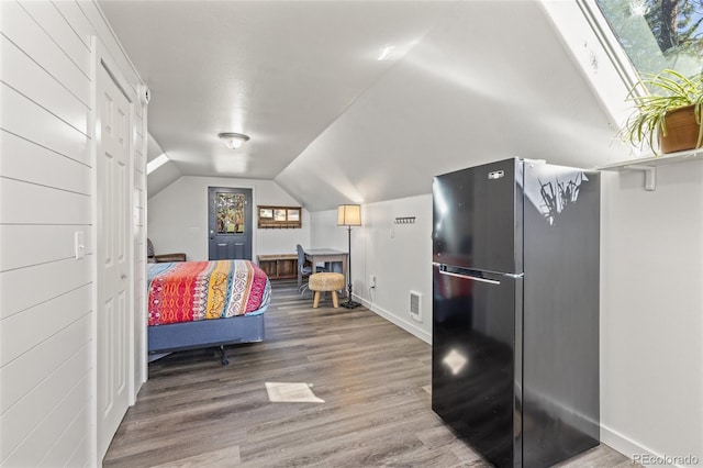 377 Homestead Rd, Bailey, CO 80421 - bedroom featuring freestanding refrigerator, wood finished floors, and vaulted ceiling