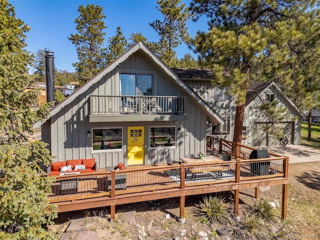 377 Homestead Rd, Bailey, CO 80421 - back of property featuring a garage, a balcony, outdoor lounge area, concrete driveway, and a deck