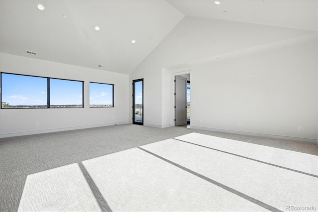 unfurnished room with high vaulted ceiling and light colored carpet