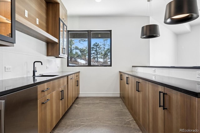 kitchen with pendant lighting, dark tile patterned floors, and sink